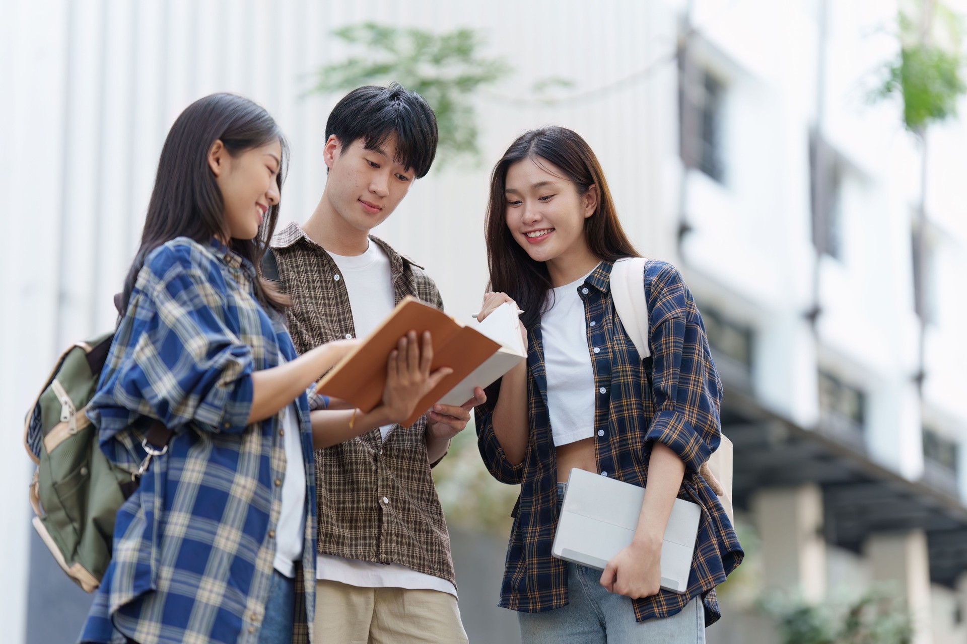 Young Asian woman college student with friends at outdoors. College student working on the college campus, education, school, study