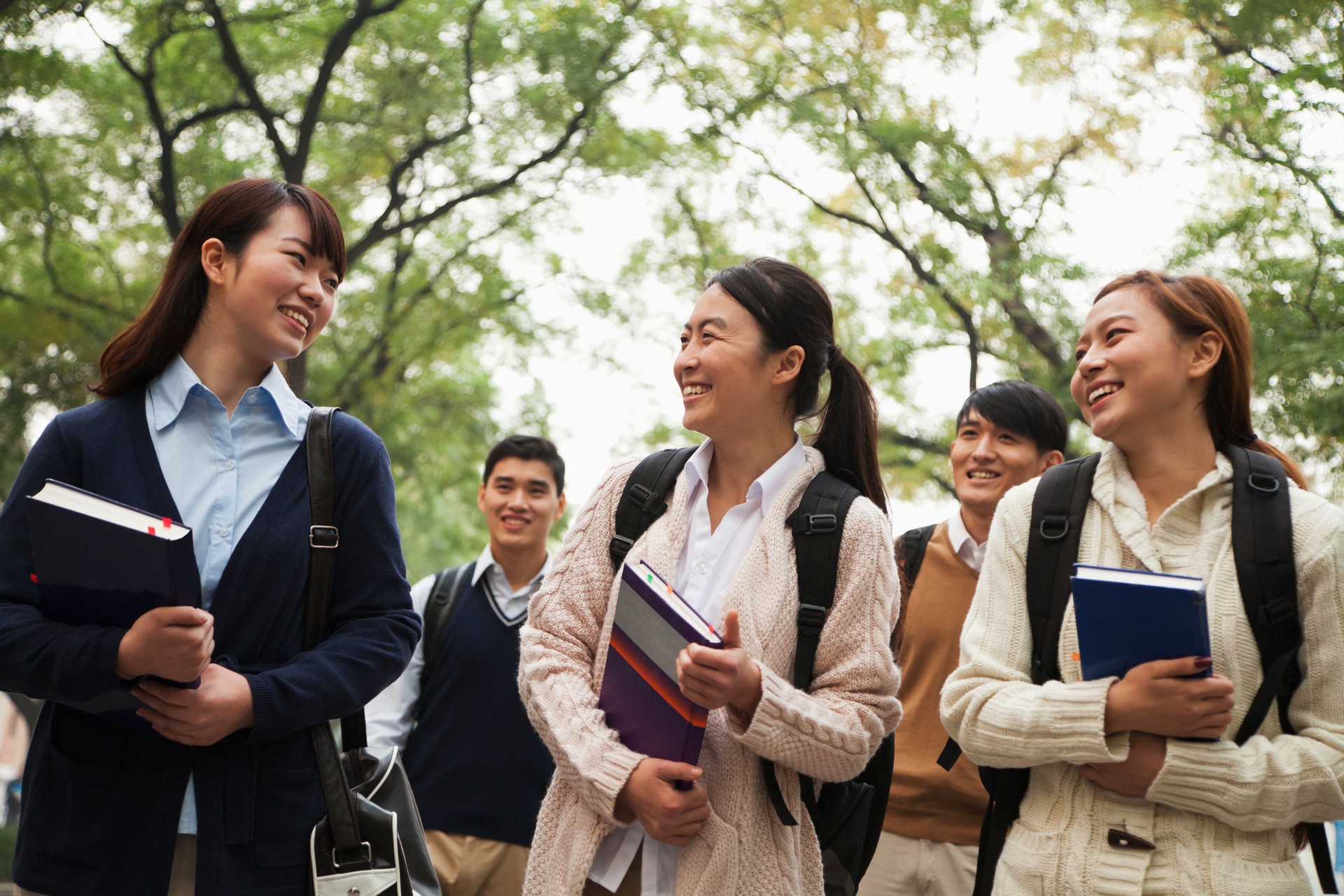 Group of Asian university students on campus with books